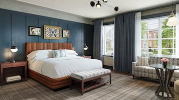Une chambre d’hôtel moderne avec un grand lit, un banc, un canapé et une table.