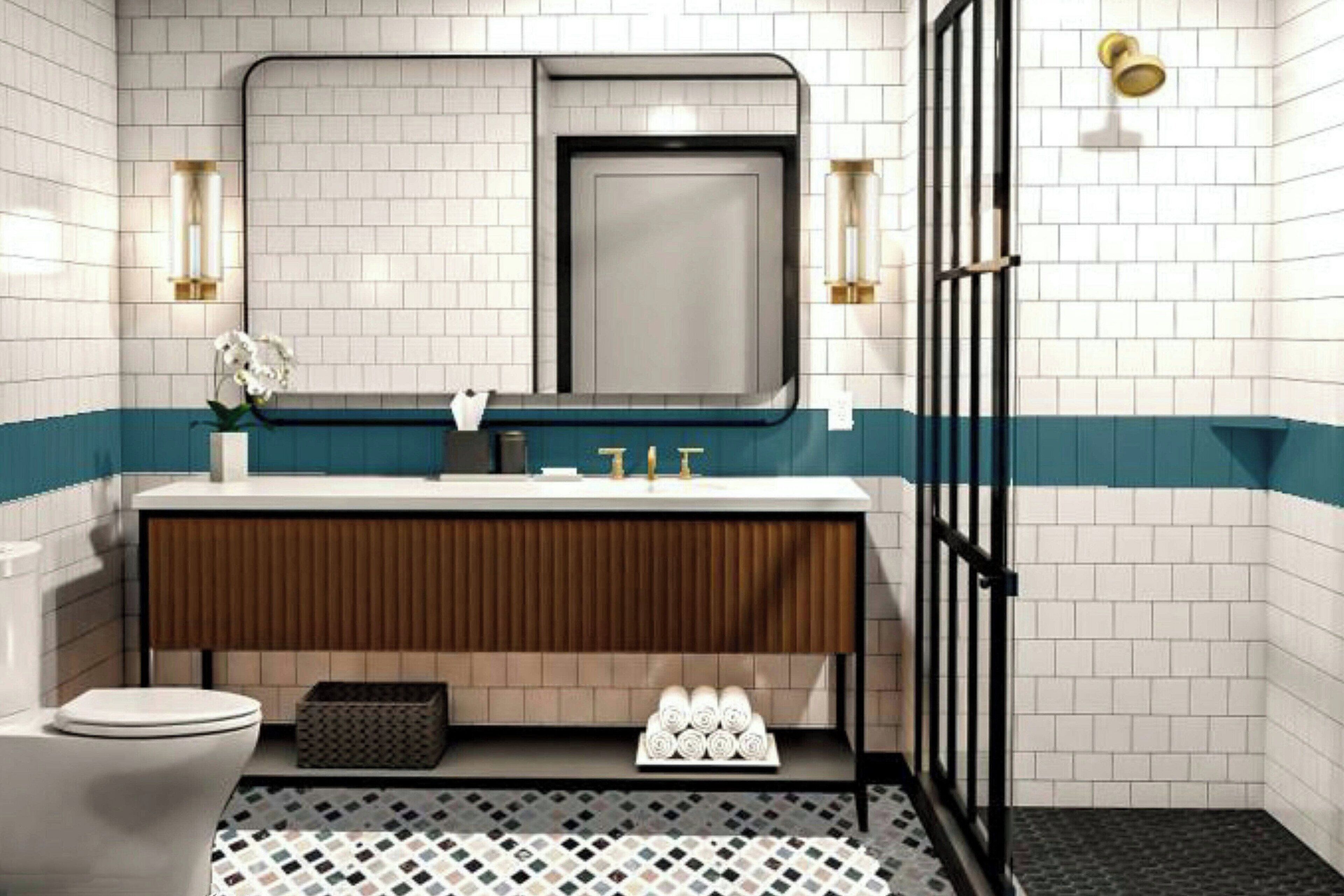 A modern bathroom with a white and teal tiled wall, a wooden vanity, a white toilet, and a black shower enclosure.