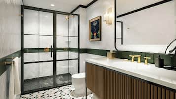A modern bathroom with a large mirror, a white sink, and a shower area.