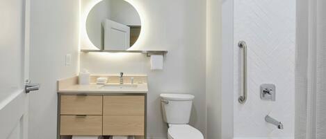 Une salle de bain moderne équipée de toilettes, d’un lavabo et d’une douche.