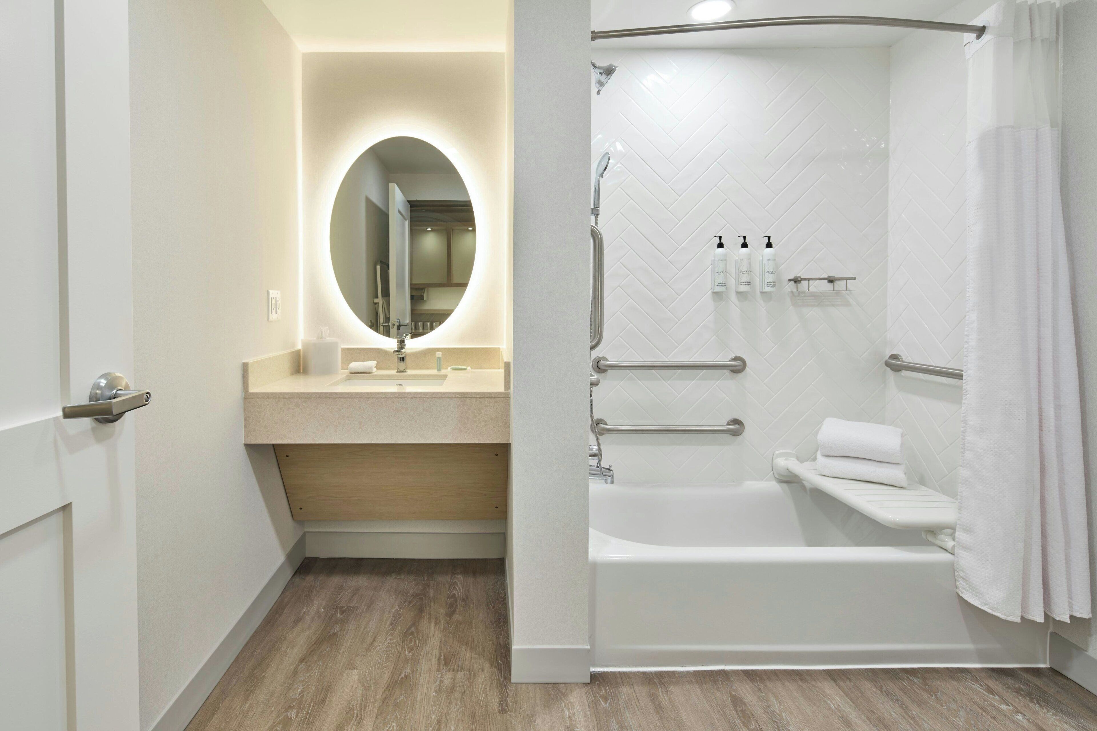 A modern bathroom with a walk-in shower, a vanity with a mirror, and a bathtub.
