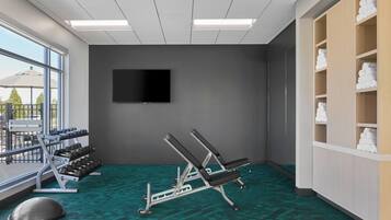 A gym with exercise equipment, a TV, and a view of the outdoors.