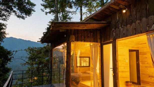 A wooden cabin with a balcony overlooking a mountainous landscape. - D Home Sapa 10 (Sa Pa)