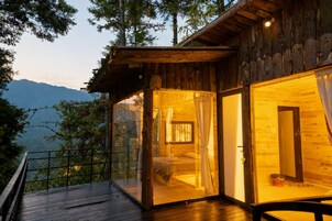 Una cabaña de madera con balcón que da a un paisaje montañoso.