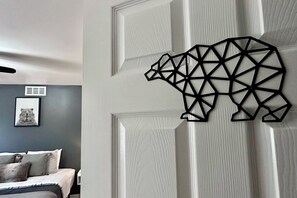 A room with a bed, a wall-mounted bear sculpture, and a framed picture. - Pocolonial Charming 4BR Mountain Retreat (Albrightsville)
