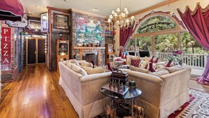 Un salón acogedor con chimenea, un tablero de ajedrez y vistas al exterior.