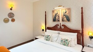 Een hotelkamer met een hemelbed, twee wandlampen en decoratieve wandkunst.