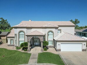 A two-story house with a tiled roof, a front entrance with a door, and a garage.