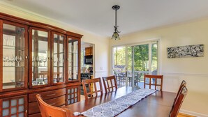 Comedor con mesa de madera, sillas y una vitrina de vidrio.