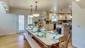 A dining area with a long table set for six, wooden chairs, and a bench. - Spacious Escape Near Mesa Verde National Park! (Mancos)