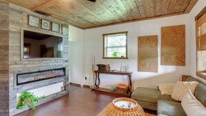 A living room with a fireplace, wooden ceiling, and a green sofa. - < 1 Mi to Downtown Arcadia: Tranquil Wooded Escape (Arcadia)