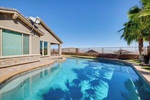 Une piscine avec une maison en arrière-plan.