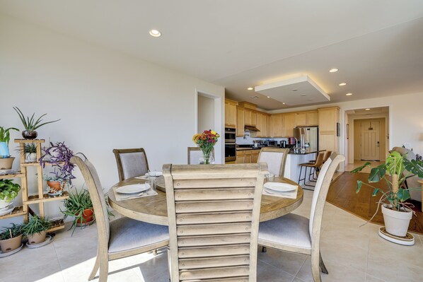 Une cuisine moderne avec des meubles en bois, un îlot central et un coin repas comprenant une table ronde et des chaises.