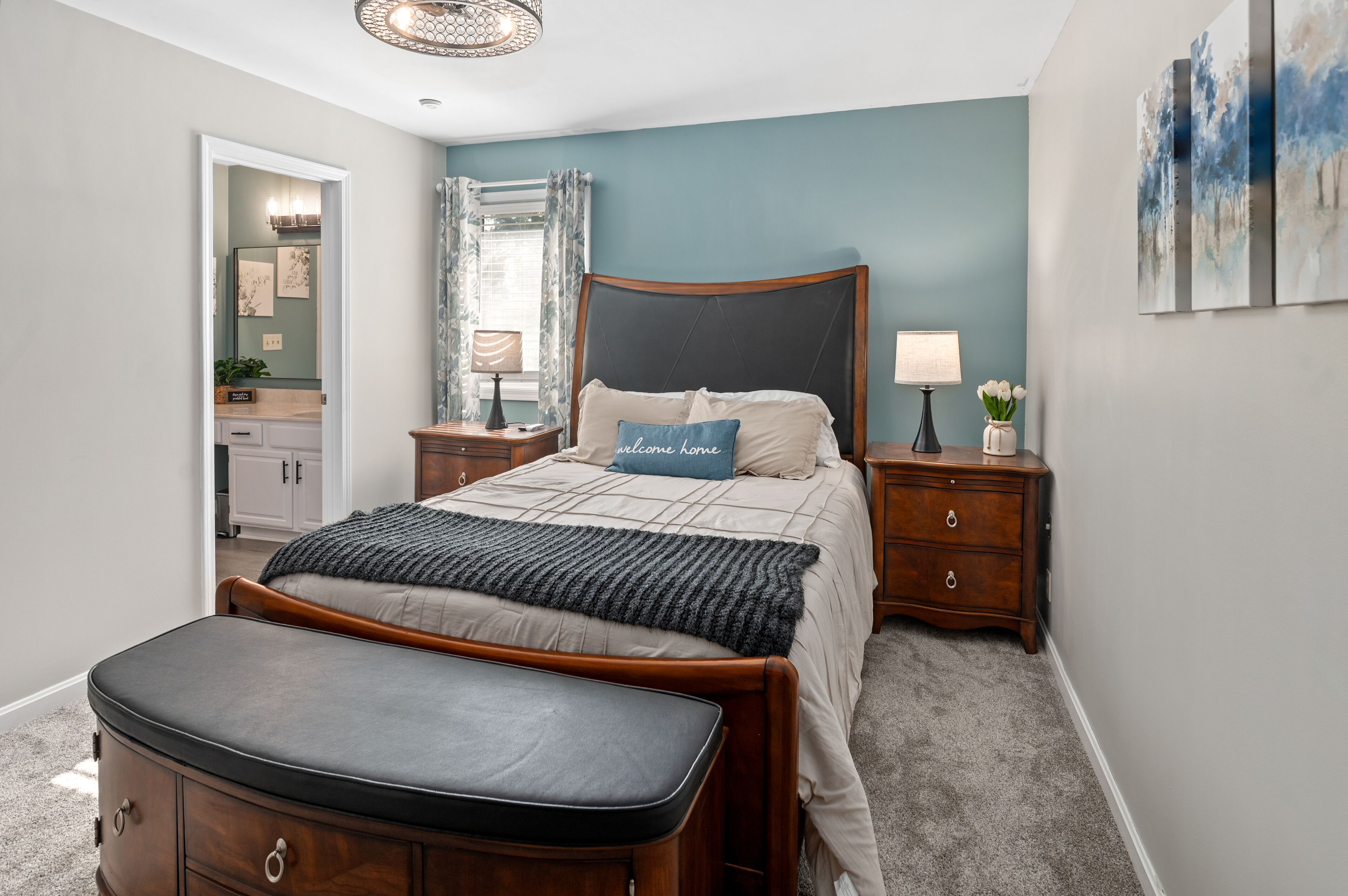 Une chambre à coucher comprenant un lit, des tables de chevet, une commode, une coiffeuse et un miroir.