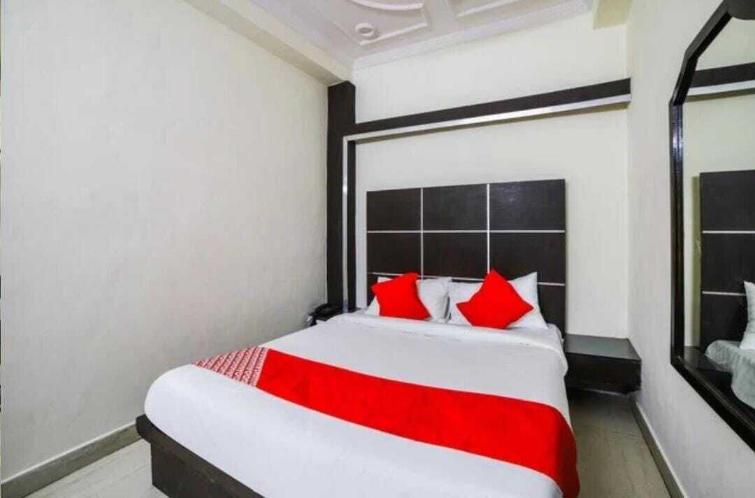 A hotel room with a large bed, a headboard, and a nightstand.