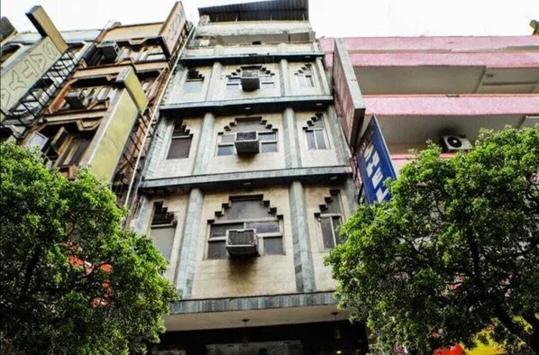Un edificio de varios pisos con un diseño arquitectónico único, que incluye una serie de balcones y ventanas.