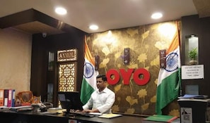 A reception desk at Anmol Hotel with the hotel's name and Indian flag decorations.