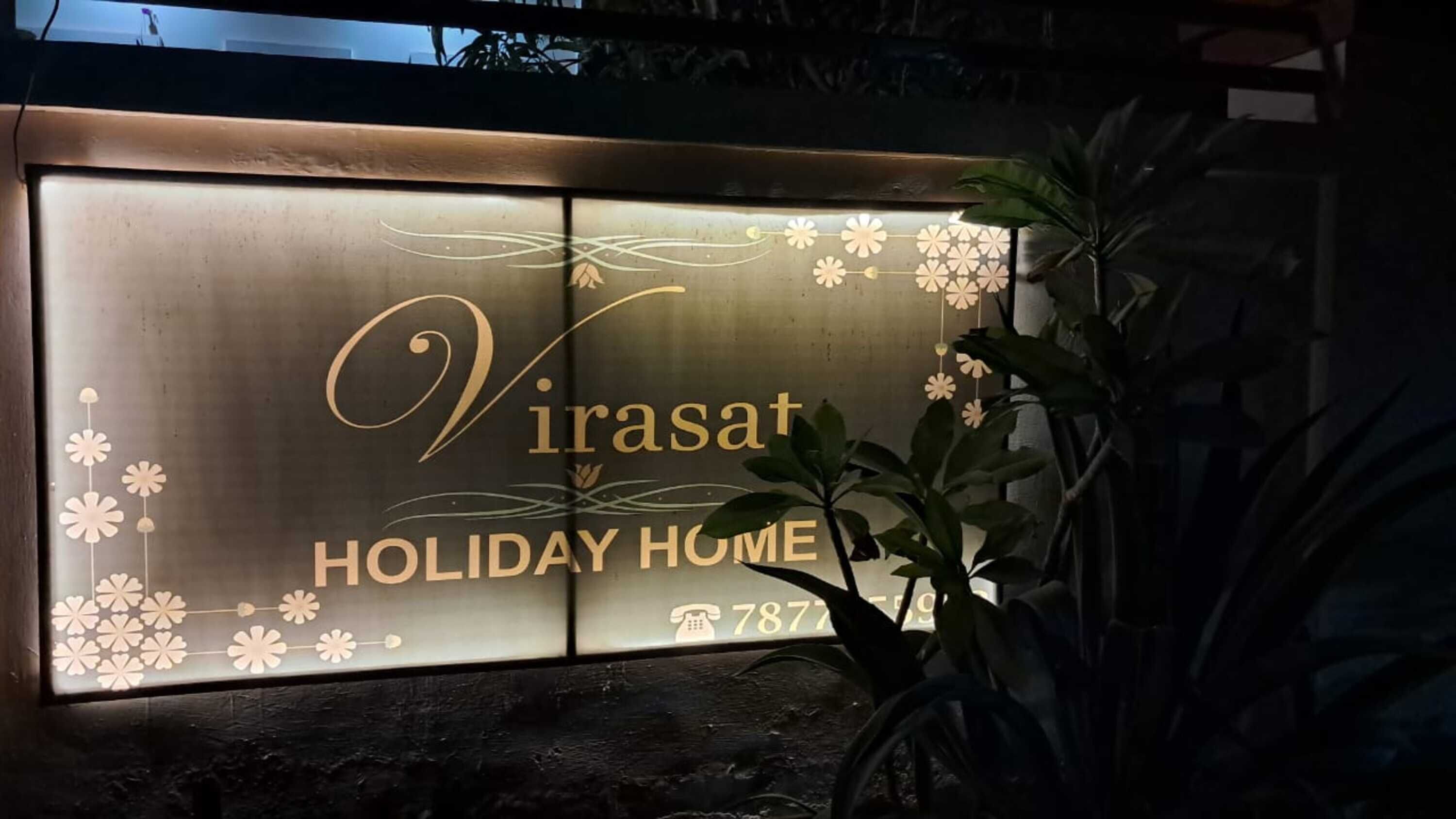 Señal de 'Virasat Holiday Home' con un número de contacto.