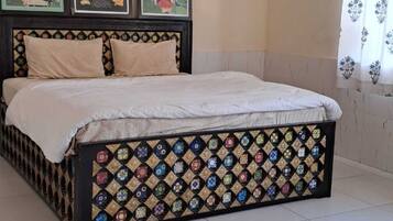 Un dormitorio con una cama, ventilador de techo y cuadros en la pared.