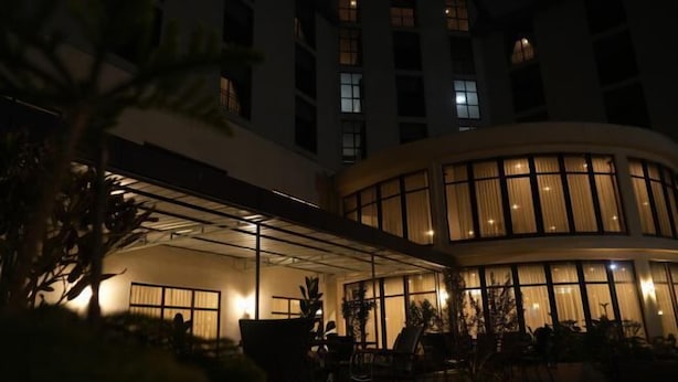 A hotel courtyard with a covered seating area, large windows, and potted plants. - Haile Hotel Wolaita (Sodo)