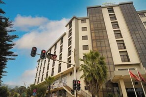 Un edificio de varios pisos con un diseño arquitectónico moderno, que presenta una escalera destacada y una serie de ventanas.