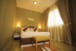 A hotel room with a large bed, bedside lamps, a wooden bench, and a nightstand. - Haile Hotel Wolaita (Sodo)