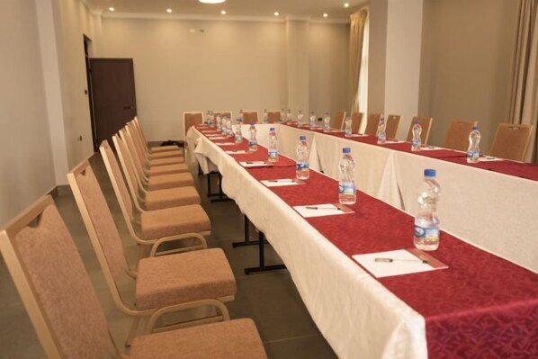 A conference room with a long table, chairs, water bottles, and nameplates.