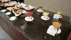 A buffet counter with various dishes and desserts, including a labeled 'Peanut Butter' dessert. - Haile Hotel Wolaita (Sodo)