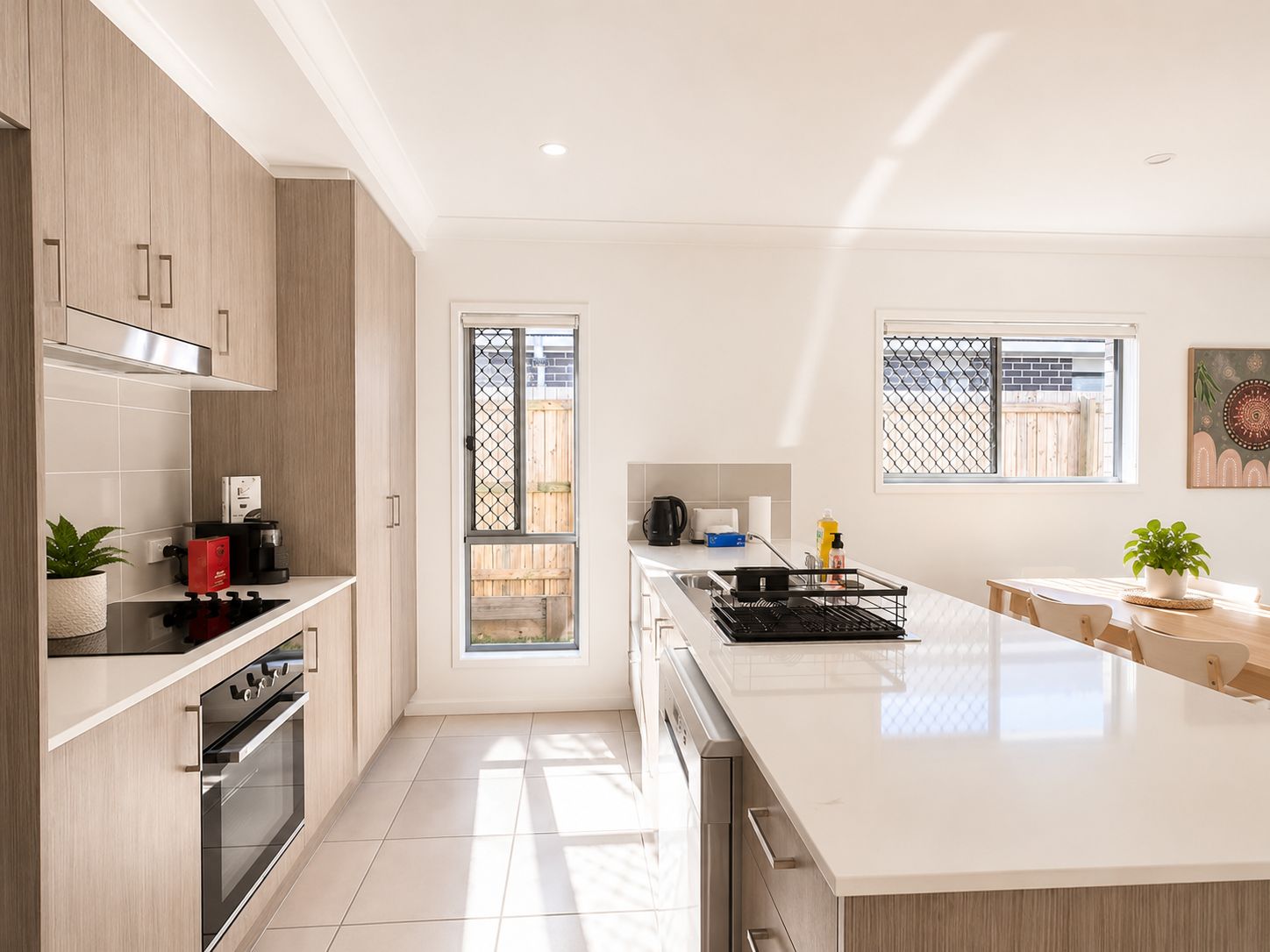 A modern kitchen with a central island, built-in oven, and a sliding glass door leading to a patio.