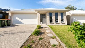 A modern two-story house with a garage, a driveway, and a well-maintained lawn. - Sparkling New Home - Suburban Charms Awaits (Park Ridge)