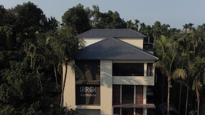 Un edificio moderno con un cartello che riporta la scritta "IRROI KAZIRANGA", immerso nel verde.