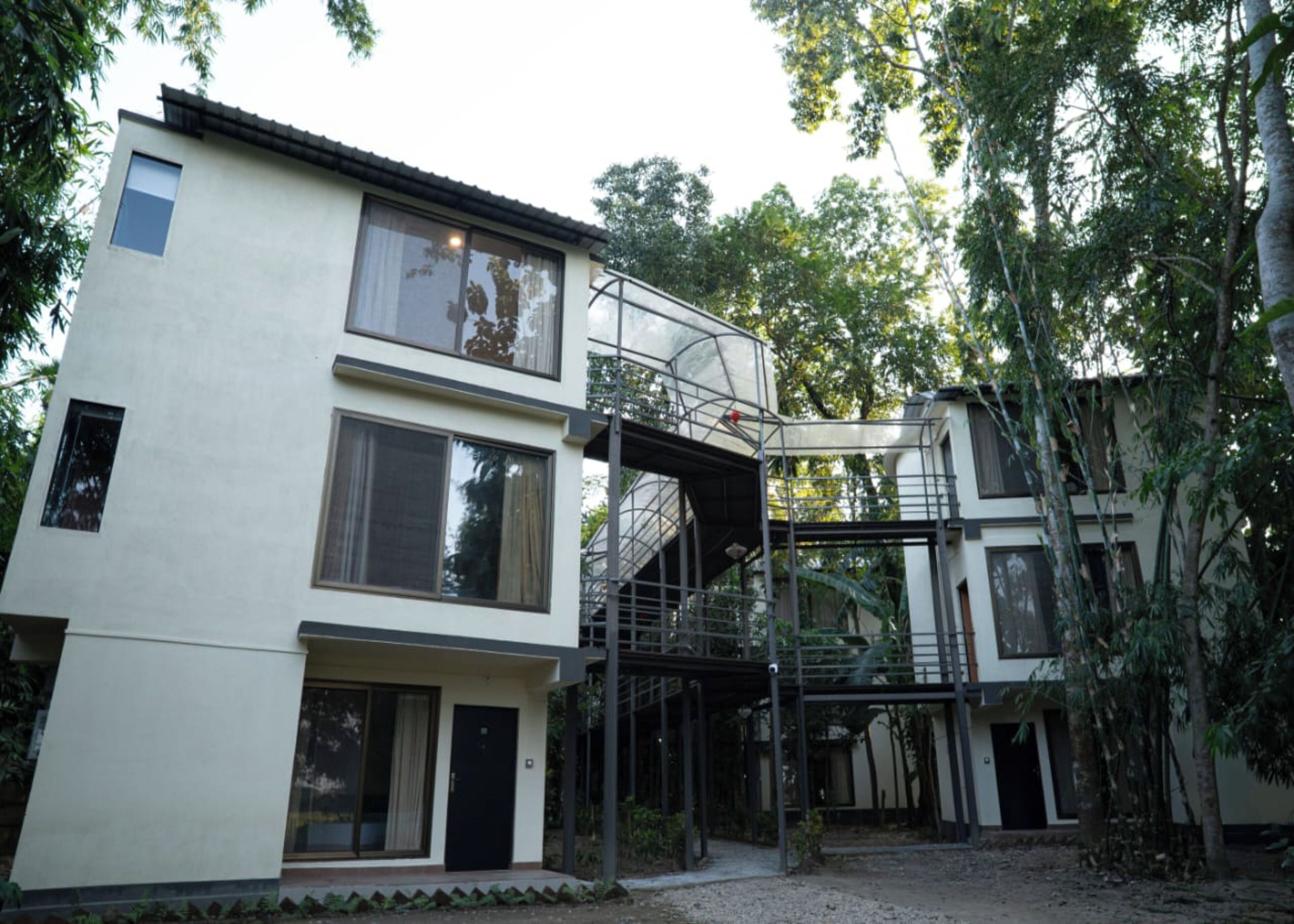 A modern two-story building with a covered outdoor staircase and large windows.