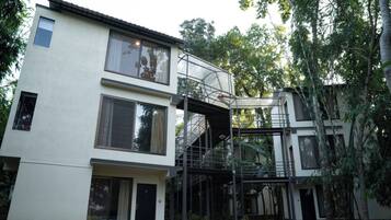 A modern two-story building with a covered outdoor staircase and large windows.