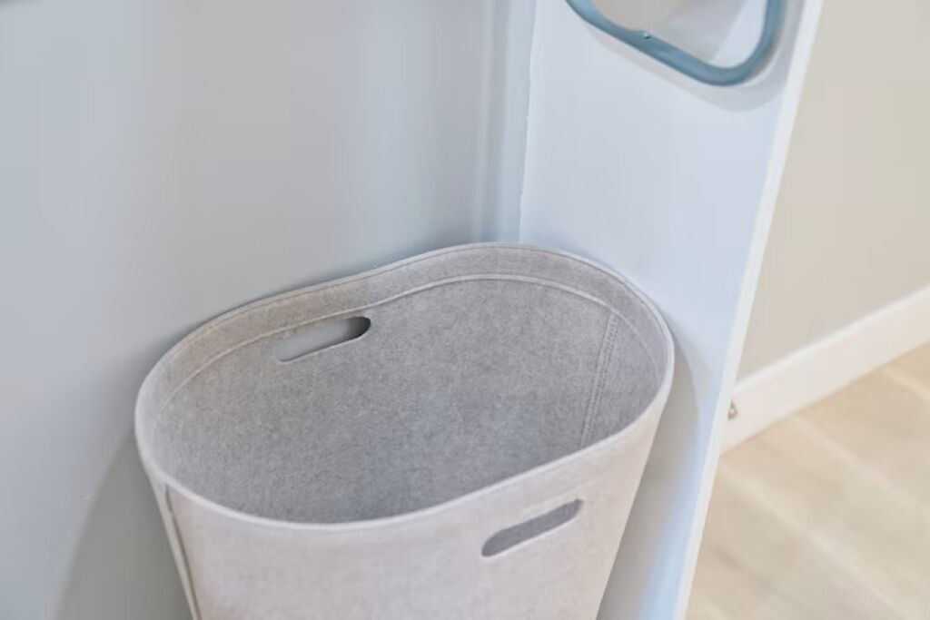 Un contenedor gris contra una pared azul claro con un picaporte.