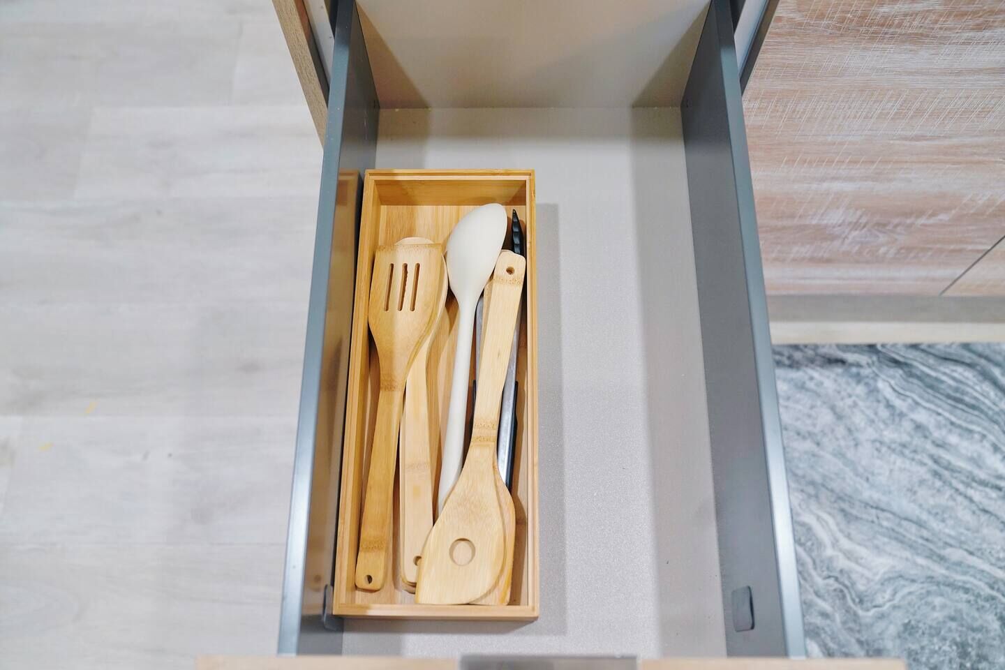 A drawer containing wooden kitchen utensils.