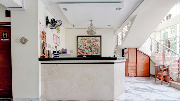 Un'ampia cucina con pavimento in marmo, un'isola centrale e una scala che conduce a un piano superiore.