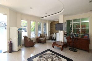 A living room with a TV, a refrigerator, a coffee table, and a patterned rug. - Collection O Jalan Malioboro Near Lempuyangan Stat (Yogyakarta)