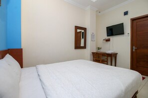 A hotel room with a bed, a desk, a chair, a television, and a door. - Collection O Jalan Malioboro Near Lempuyangan Stat (Yogyakarta)