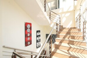 A staircase with metal railings, a handrail, and artwork on the walls. - Collection O Jalan Malioboro Near Lempuyangan Stat (Yogyakarta)