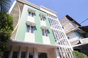 A multi-story building with a green facade, multiple windows, and a visible entrance. - Collection O Jalan Malioboro Near Lempuyangan Stat (Yogyakarta)