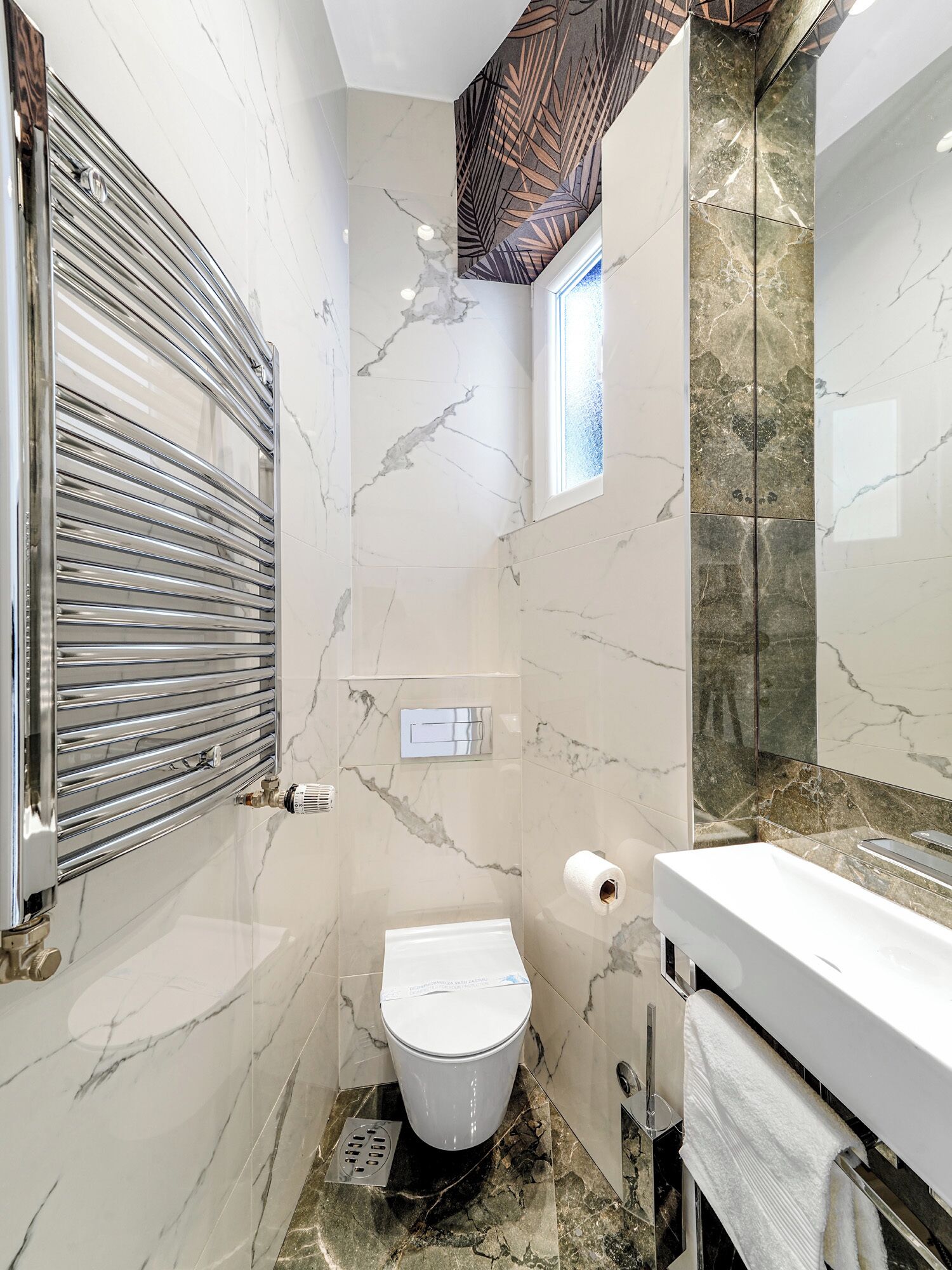 Ein kleines Badezimmer mit Toilette, Dusche und Waschbecken.
