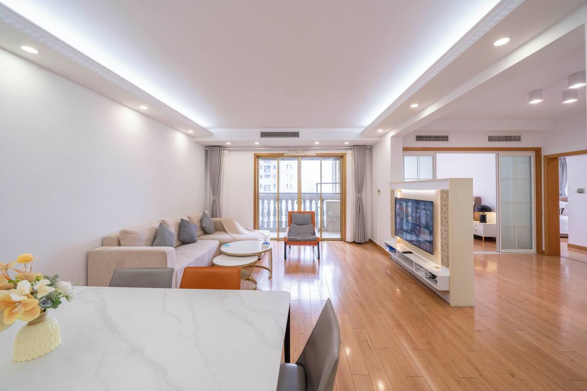 Un salon moderne avec un canapé, une table basse et un téléviseur.