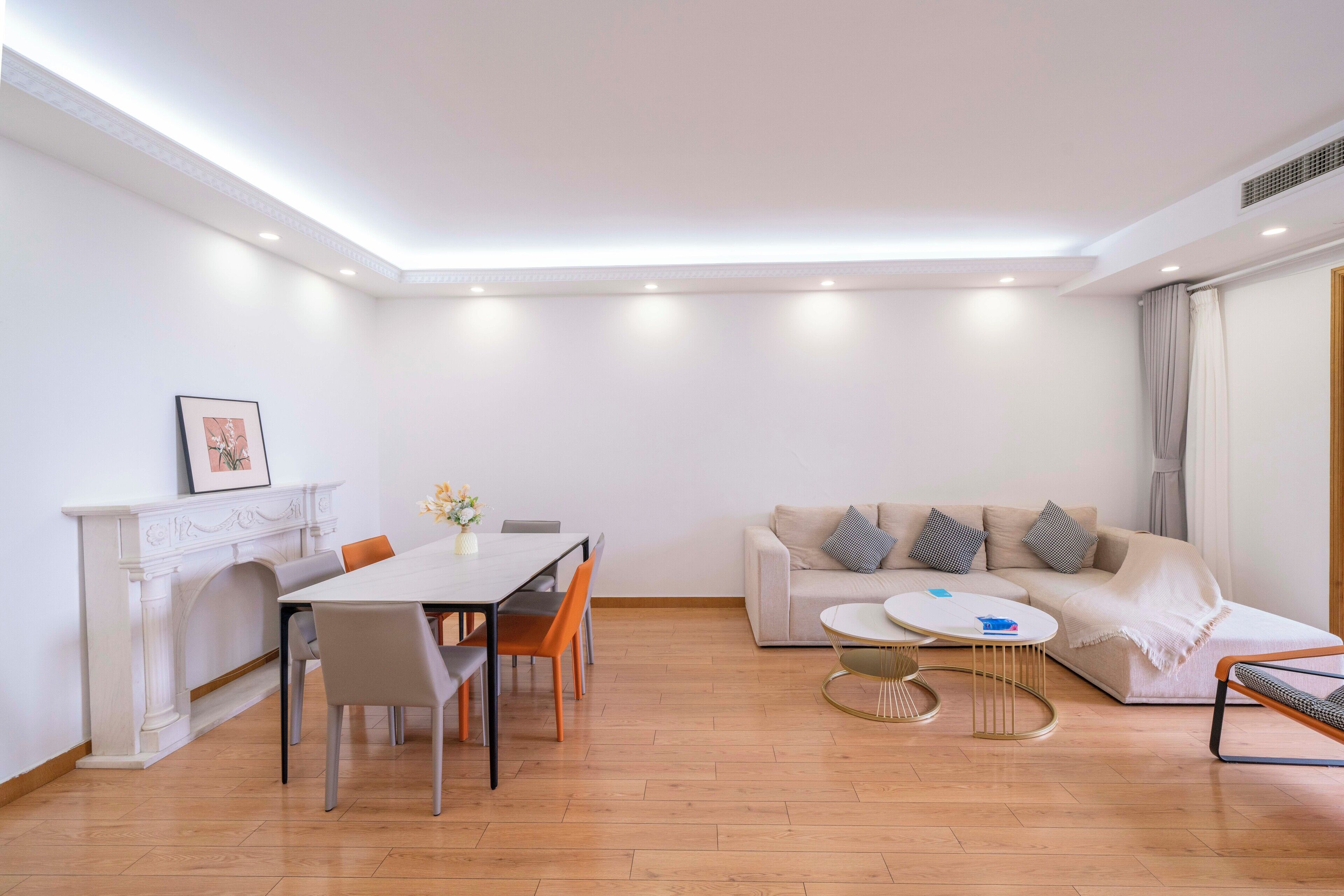 A modern living room with a dining area, a fireplace, a sofa set, and a coffee table.