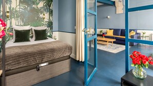 A modern hotel room with a bed, a sofa, and a dining area. - Merveil Luxury Suite - Saint Denis I (Paris)