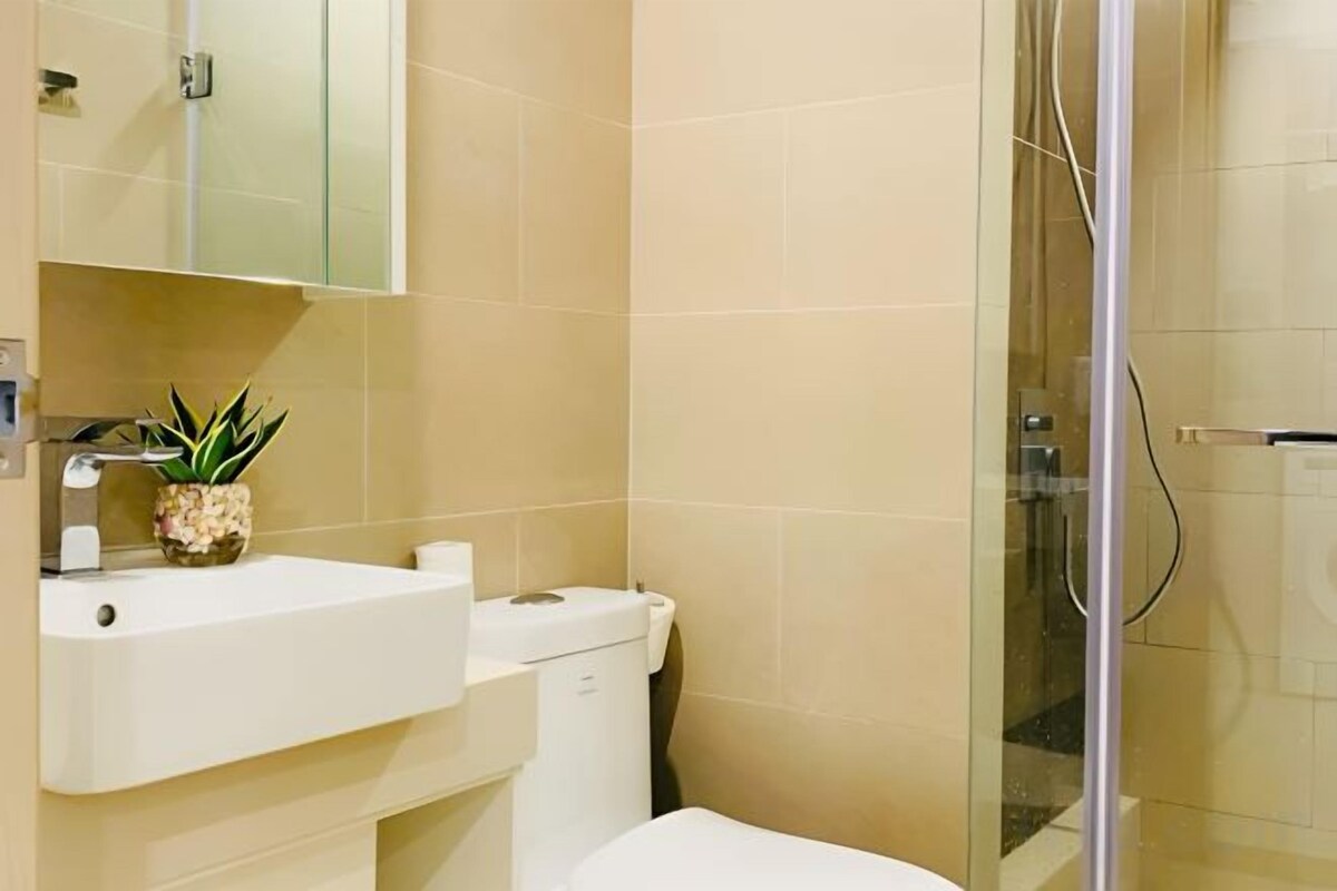 A bathroom with a sink, toilet, and a glass shower enclosure.