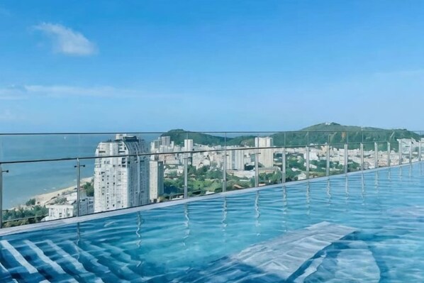 Une piscine à débordement située sur le toit, offrant une vue sur la ville.