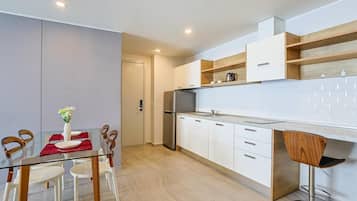 Appartement, balkon | Privékitchenette | Een koelkast met diepvriezer, een microgolfoven, een kookplaat