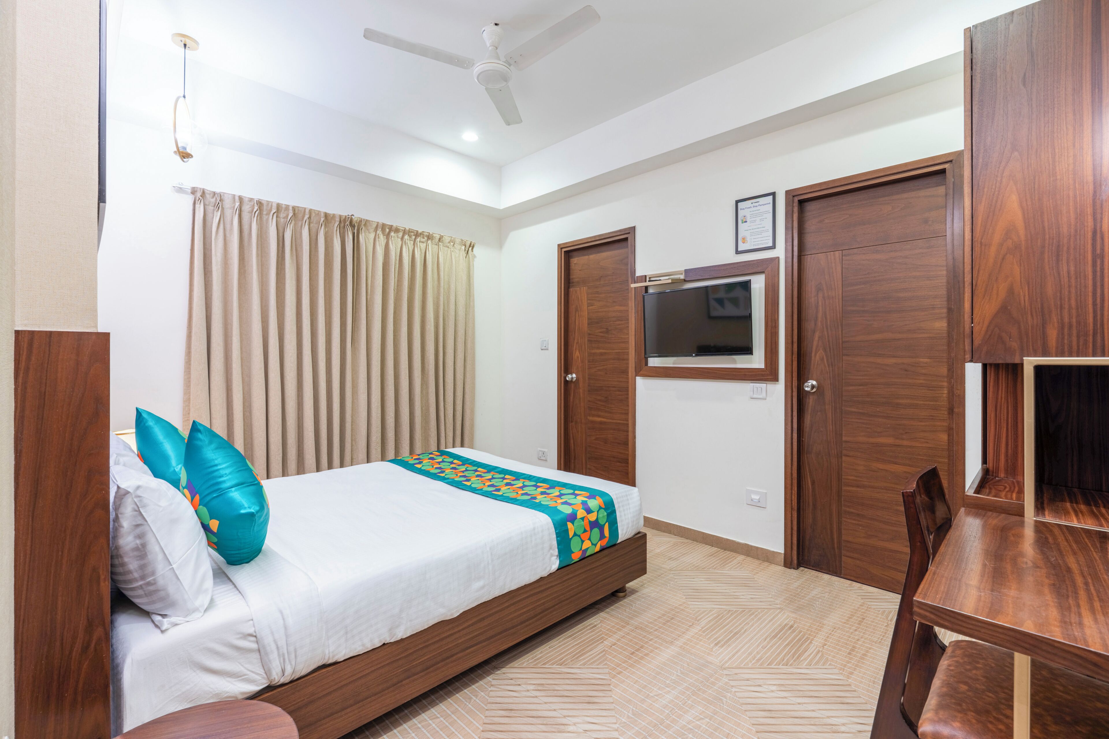 A bedroom with a bed, a desk, and a wardrobe.