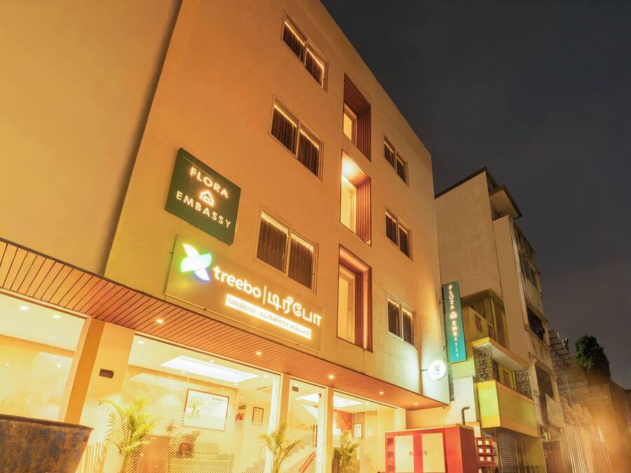 A hotel with a sign for 'Flora Embassy' and 'Treebo'.