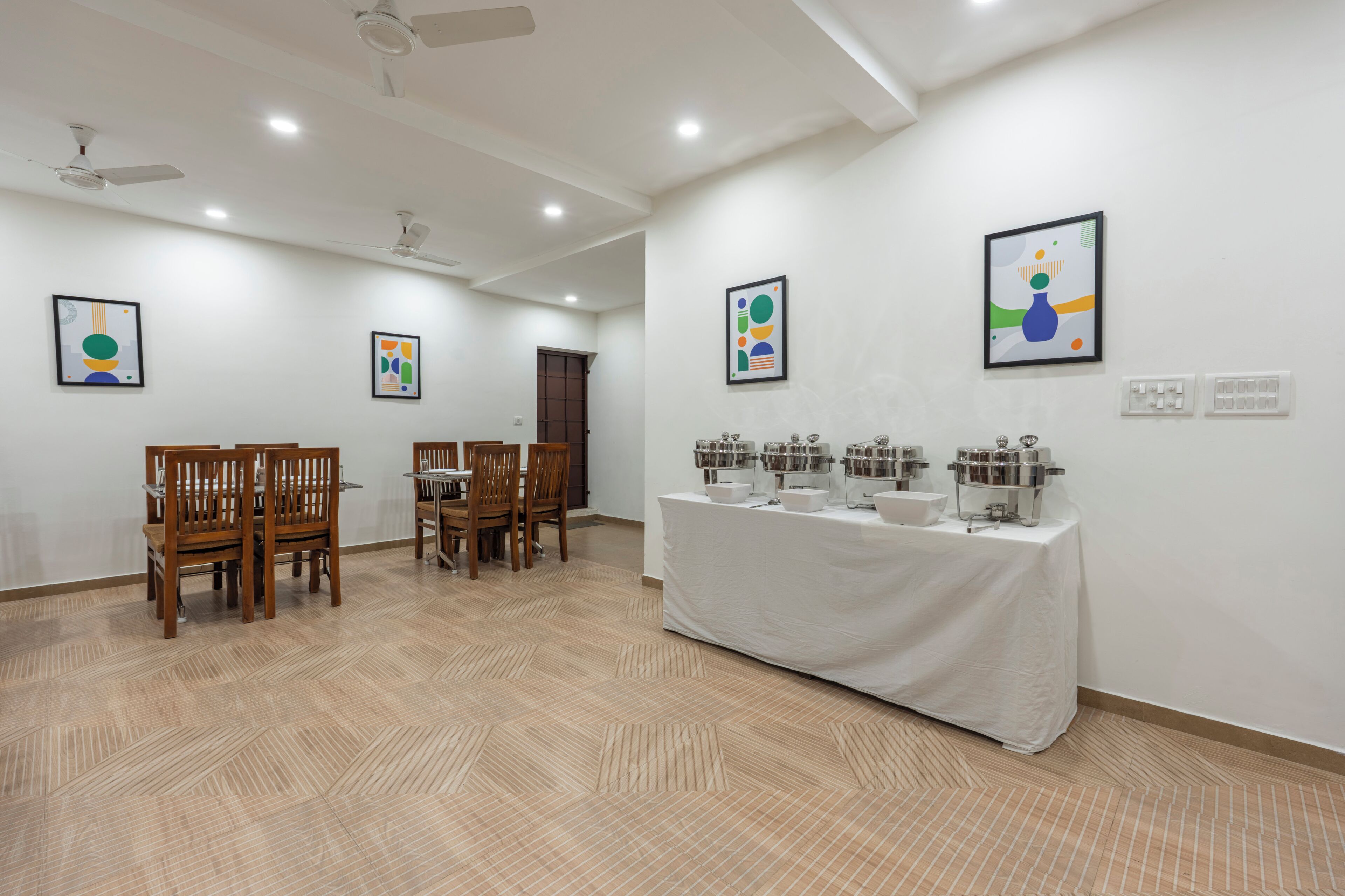 A conference room with a long table, chairs, and a buffet setup.